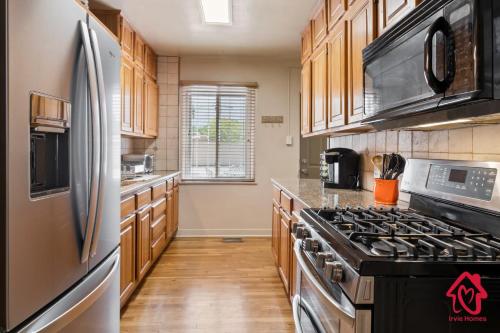 a kitchen with wooden cabinets and a stainless steel refrigerator at The Dartmouth House in Albuquerque