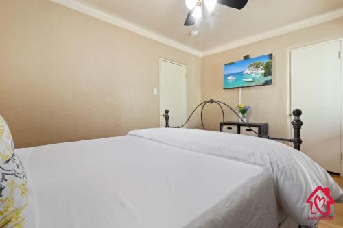 a bedroom with a white bed and a ceiling fan at The Dartmouth House in Albuquerque