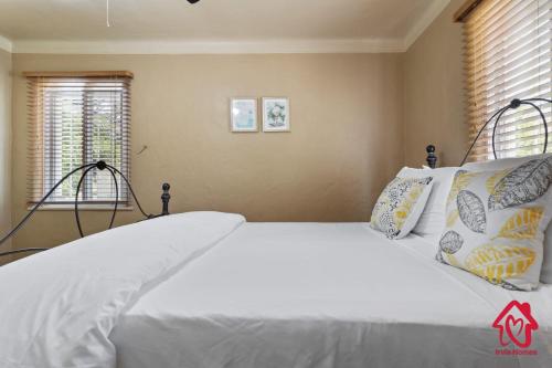 a bedroom with a large bed with white sheets and pillows at The Dartmouth House in Albuquerque