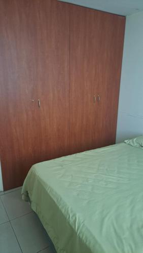 a bedroom with a bed and wooden cabinets at Habitación para una persona en Samborondón La Aurora in Estancia Vieja