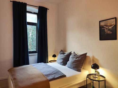 卡爾斯魯厄的住宿－Zen Apartment - 2 bedrooms - kitchen，卧室配有带枕头的床铺和窗户。