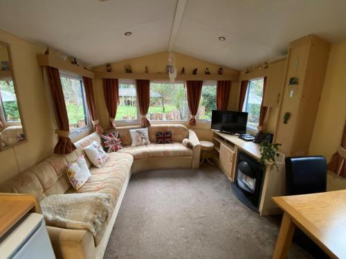 a living room with a couch and a tv at Secluded Woodland Hideaway - 2 Bed with Private Parking in Emsworth