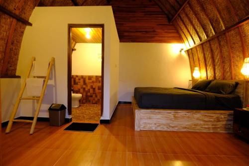 um quarto com uma cama e uma porta para uma casa de banho em Volcano Cabins em Kubupenlokan