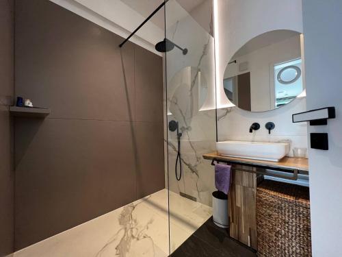 a bathroom with a shower with a sink and a mirror at New exclusive 2 bedroom apartment Hamburg in Hamburg