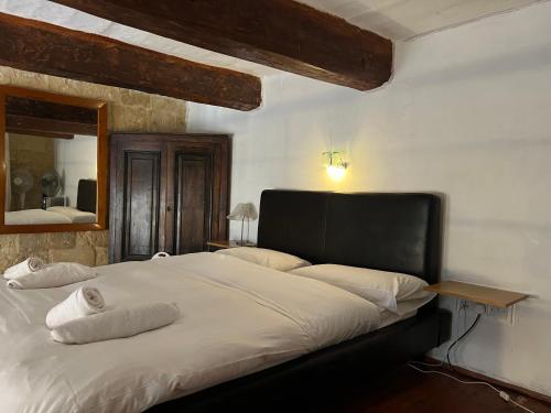 a large bed in a bedroom with a mirror at Valletta Period Townhouse in Valletta