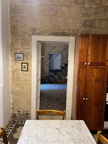 a dining room with a table and a staircase at Valletta Period Townhouse in Valletta