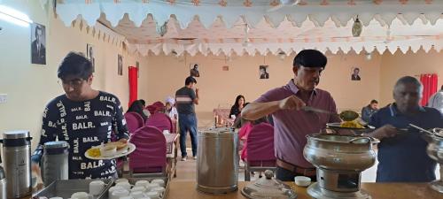 un groupe de personnes préparant des repas dans une cuisine dans l'établissement Jaisalmer Royal Desert Safari Camp, à Sām