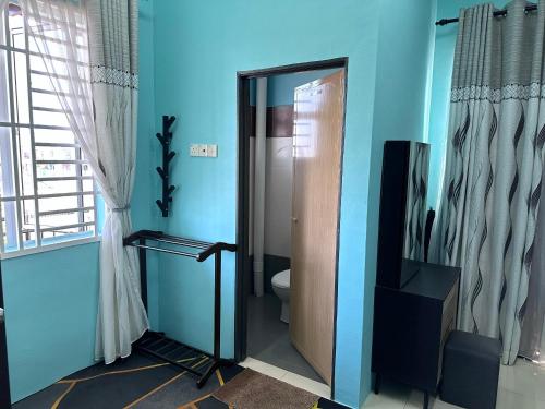 Pokok Sena的住宿－Homestay Sejahtera，一间带卫生间和门的浴室以及一台电视