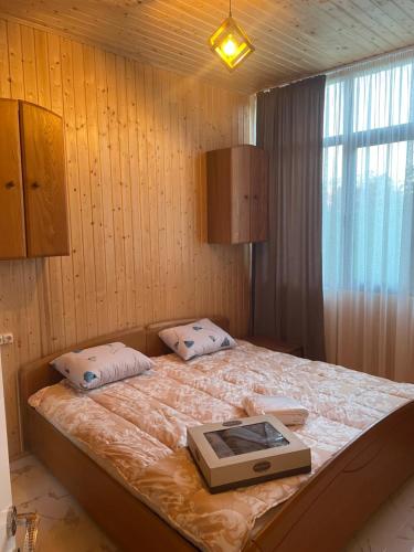 een slaapkamer met een bed met een boek erop bij GT Cotteges in Batoemi
