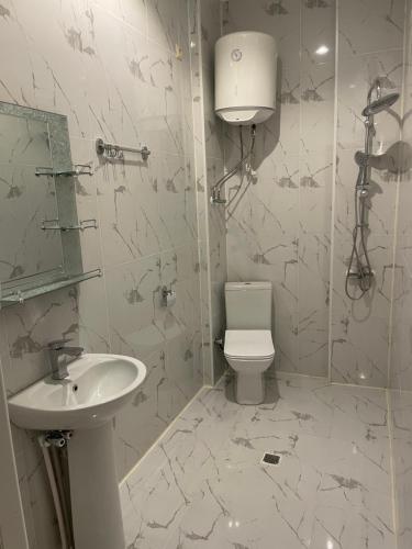 uma casa de banho branca com um WC e um lavatório em GT Cotteges em Batumi