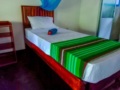 a bed with a hat sitting on top of it at Pride Rock Villa & Tree House in Sigiriya