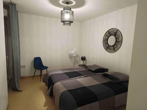 ein Schlafzimmer mit einem Bett, einem Spiegel und einem Stuhl in der Unterkunft Appartement T2 - PMR à 750 Mètres de la Station Thermale d'Avène (34) in Avène