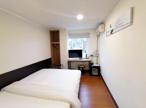 a bedroom with a bed and a desk with a computer at 富裕商旅 RICH-hotel in Taitung City