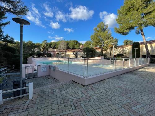 une piscine entourée d'une clôture dans l'établissement Studio climatisé piscine et proche plage, à Sanary-sur-Mer