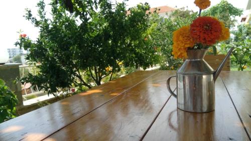 eine Vase mit Blumen auf einem Holztisch in der Unterkunft Villa Paja in Ksamil