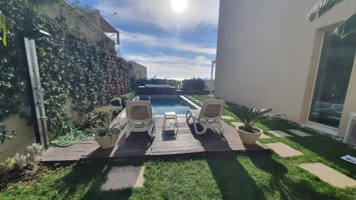 een patio met 2 stoelen en een zwembad bij Villa with Private Pool and Jacuzzi, Palase! in Himare