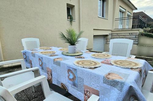 a table with a blue table cloth on a patio at Maison chaleureuse 4 chambres avec jardin - Proche Paris Jeux olympiques 2024 - ARENA Paris Nord Villepinte - Parc des expositions - Aéroport CDG - Disney in Tremblay En France