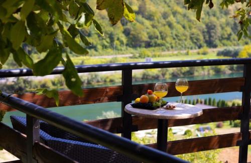 a table with two glasses of wine on a balcony at Holiday Home Aladin's in Bihać