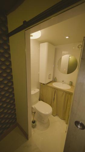 une salle de bain avec des toilettes blanches et un lavabo dans l'établissement Escale à Boinville, à Prunay-le-Gillon