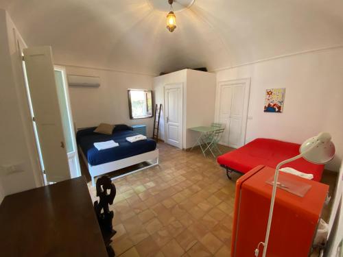 1 dormitorio con 1 cama y 1 maleta roja en Villa Lavinia, en Santa Marina Salina