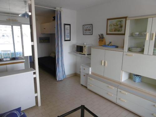une cuisine avec des armoires blanches et un micro-ondes dans l'établissement Appartement 5 pers avec loggia, parking privé à Sète - FR-1-472-166, à Sète