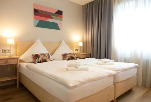 um quarto com uma grande cama branca em frente a uma janela em Hotel Herrnbrod & Ständecke em Dreieich