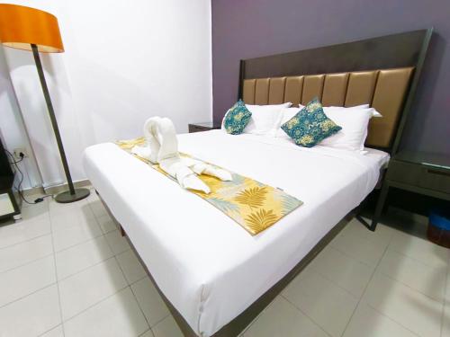 a bedroom with a large bed with white sheets and pillows at Salaam Suites Hotel in Kota Bharu
