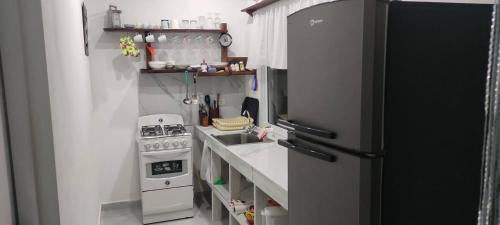 a small kitchen with a stove and a refrigerator at Meridiana in Las Terrenas