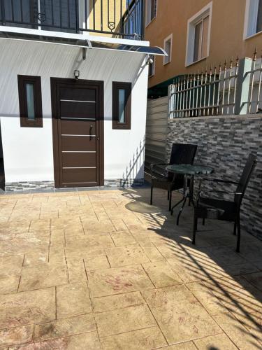 a patio with two chairs and a table in front of a building at Maria’s studio in Paphos City