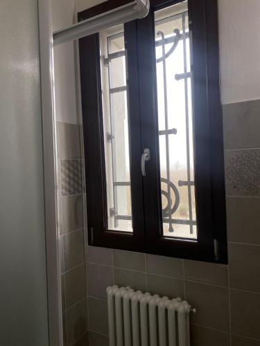 a bathroom with a window and a radiator and a window at B&B Molinetto in Piacenza