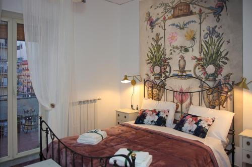 Casa Graziosa في إيركولانو: غرفة نوم بسرير مع جدار ازهار