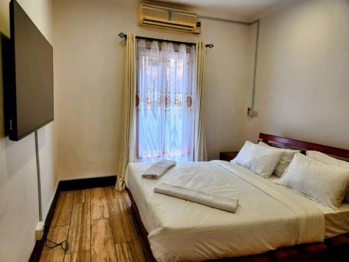 - une chambre avec un grand lit et une fenêtre dans l'établissement Cozy 2 bedroom in Moshi Town, à Moshi