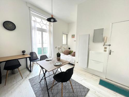 une cuisine et un salon avec une table et des chaises dans l'établissement L'Echappée Urbaine - Joli studio en hypercentre, à Poitiers