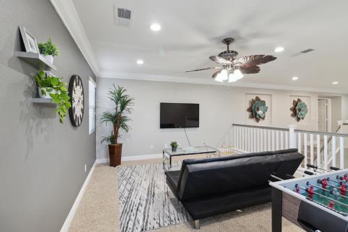 a living room with a black leather couch and a tv at 5BR 3BA Home - King Beds - Fast Wifi home in Victorville