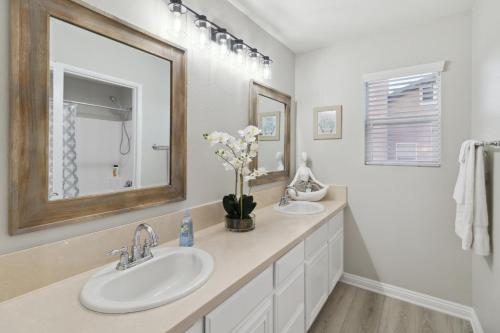 a bathroom with two sinks and a mirror at 5BR 3BA Home - King Beds - Fast Wifi home in Victorville