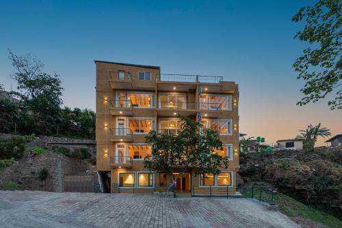 a building with a tree in front of it at Ekawa Ganga by Lawrence Hotels in Rishīkesh