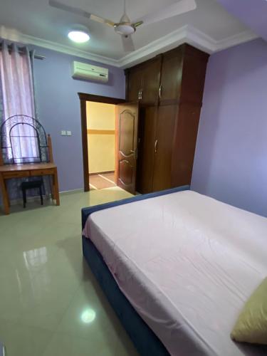 ein Schlafzimmer mit einem Bett und ein Zimmer mit einer Tür in der Unterkunft Kate Villa in Kumasi
