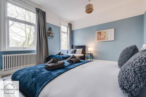 a bedroom with a large bed with blue walls at Elegant Home from Home in Manchester