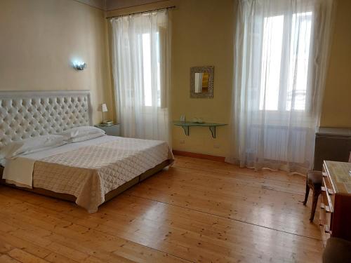 Schlafzimmer mit einem weißen Bett und Holzboden in der Unterkunft Residenza Al Corso Suites in Rom
