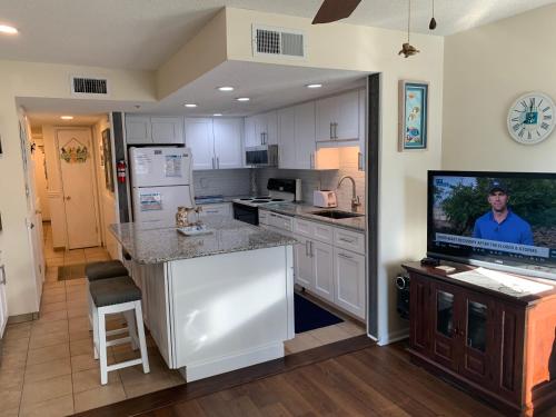 a kitchen with white cabinets and a flat screen tv at Carolina Shores ll in Myrtle Beach