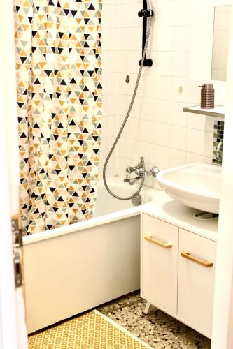 une salle de bain avec un rideau de douche et un lavabo dans l'établissement T1 près de Paris Wifi/Netflix/Parking/Balcon, à LʼHay-les-Roses