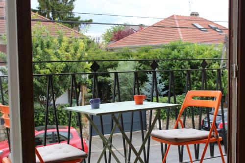une table et deux chaises sur un balcon dans l'établissement T1 près de Paris Wifi/Netflix/Parking/Balcon, à LʼHay-les-Roses