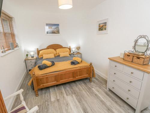 a bedroom with a bed and a dresser at The Pepper Pot Retreat in Ventnor