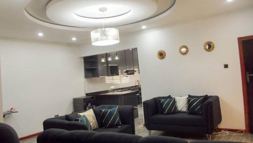 sala de estar con 2 sofás y techo en KKI Serviced Apartments en Lusaka