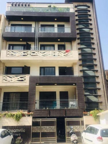 a tall building with a car parked in front of it at A J residency in New Delhi