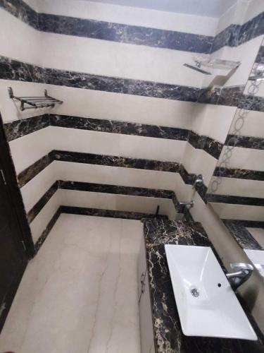 a bathroom with a sink and a black and white wall at A J residency in New Delhi