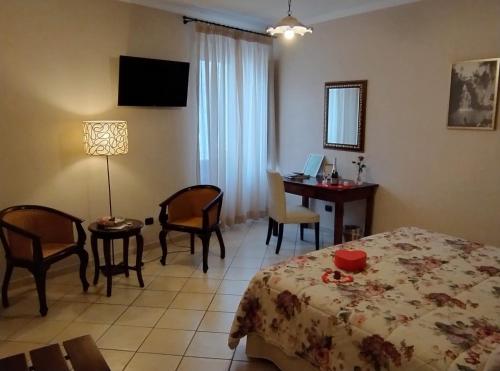 um quarto com uma cama, uma secretária e uma mesa em B&B Vicidomini em San Marco dei Cavoti