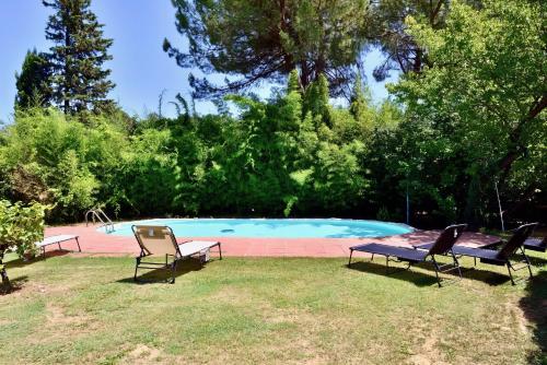 three chairs and a table next to a swimming pool at Molino in chianti in Mercatale Val Di Pesa