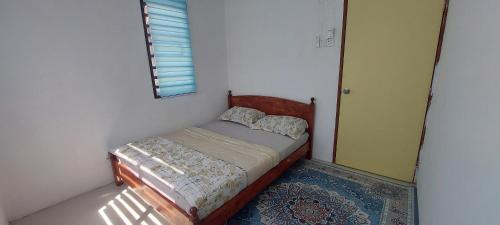 a small bedroom with a bed and a mirror at KASIH JERAI HOMESTAY, Gurun, Guar Chempedak in Guar Chempedak