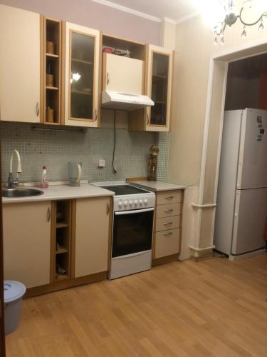 eine Küche mit einem weißen Kühlschrank und einer Spüle in der Unterkunft Квартира in Almaty